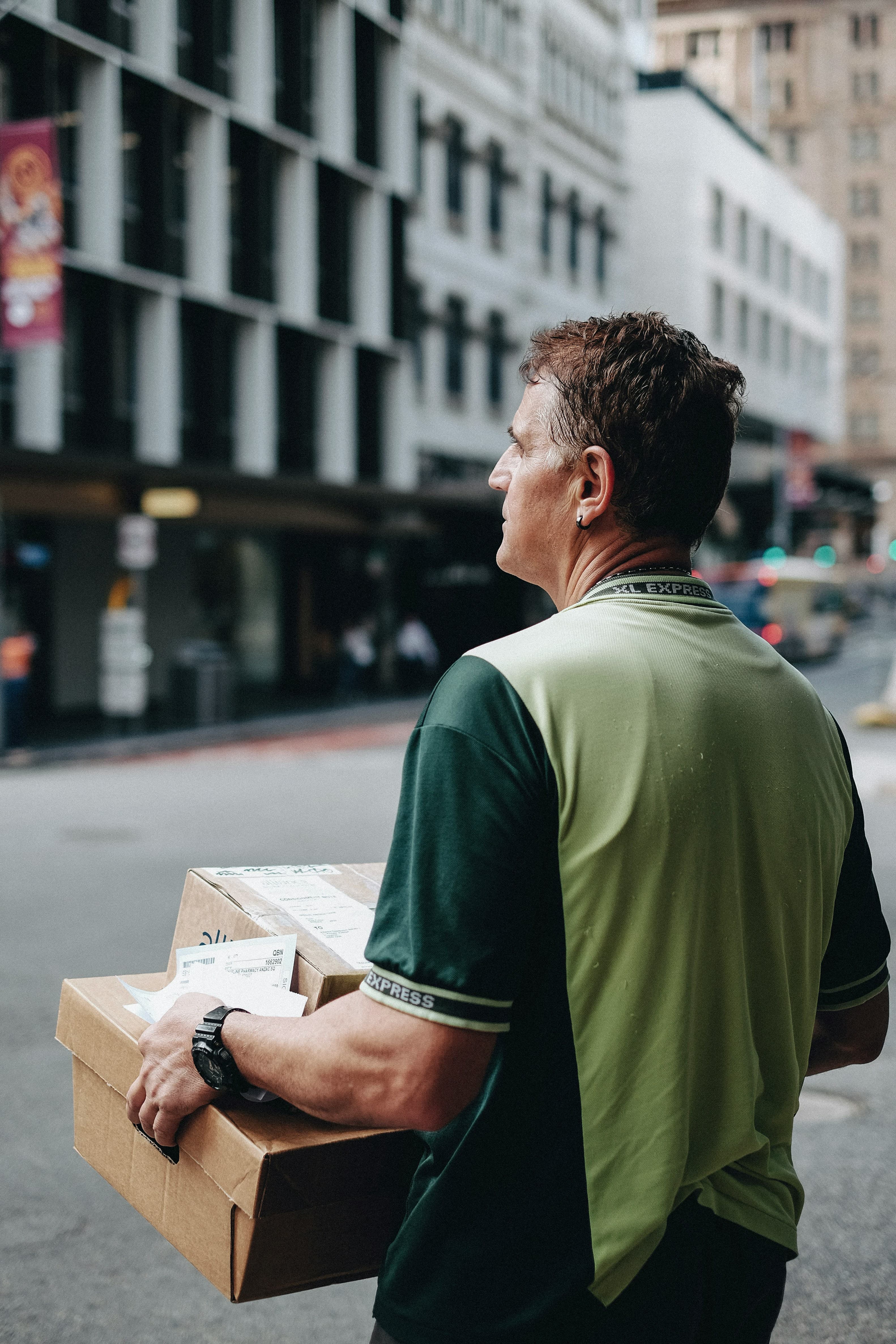 Courier carrying cardboard boxes on a delivery route